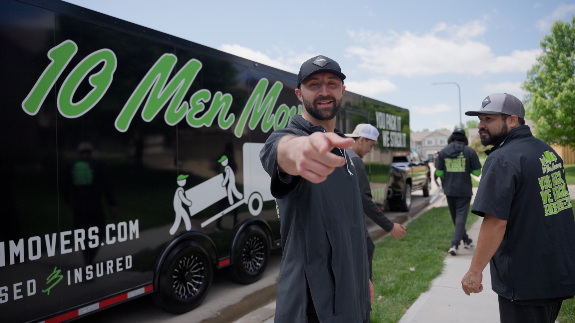 The owner of 10 Men Movers standing in front of a branded moving truck